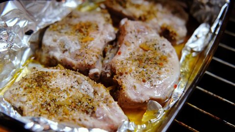 Oven roasted meat steaks with spices in foil.