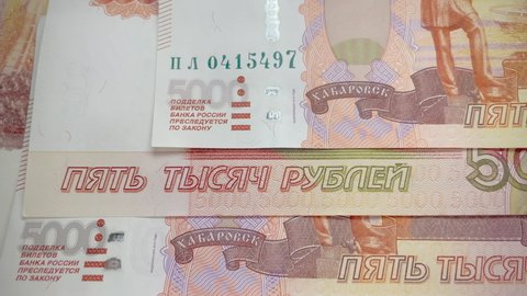 Five thousand ruble banknotes zooming slowly. The text "Bills of the Bank of Russia" counterfeiting is punishable by law" close-up. Money counterfeiting. State currency of the Russian Federation.