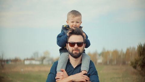 Happy Family Father Day And Child Son Leisure. Boy Son Sitting On Father Neck. Cute Little Kid Having Fun. Carefree Dad With Preschool Son Enjoy Activity Adventure. Family Parent Holidays Relationship