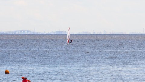 Gulf of Finland (near St. Petersburg), Russia, July 2021: Windsurfer surfing in the wind in summer. Competitions in windsurfing.