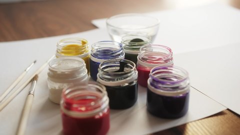 Multicolored gouache in small jars with tassel.