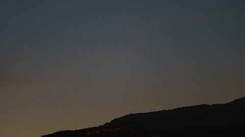 Stars falling to the ground in front of mountain silhouette with bright planet venus