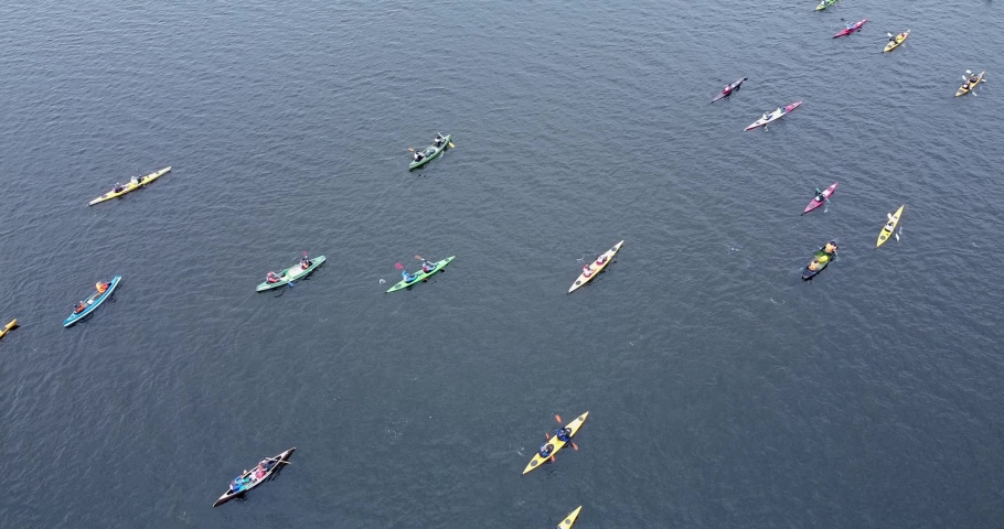 Colorful canoers paddling on a tranquil water. Boats, kayak, canoe, paddling, rowing. Top down view of a competition. Water sports. Outdoor activities. . High quality FullHD footage