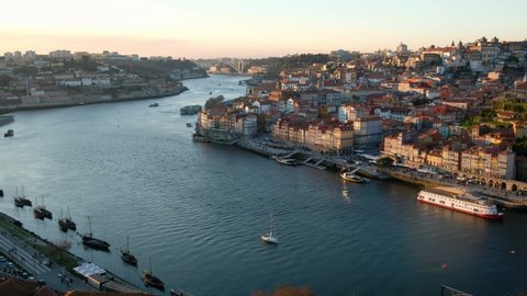 Aerial time laps of Porto river. Oporto, Douro River. Stunning sunset time lapse. Sun is moving away from the city. Old town, Portugal. Boats moving on the river. Sunset colors. . High quality 4k 