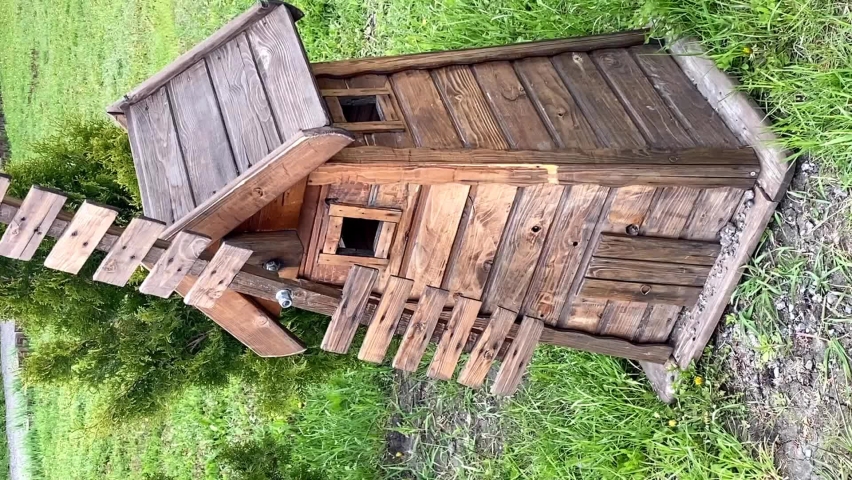 the wind turns the blades of a small wooden mill on a summer day