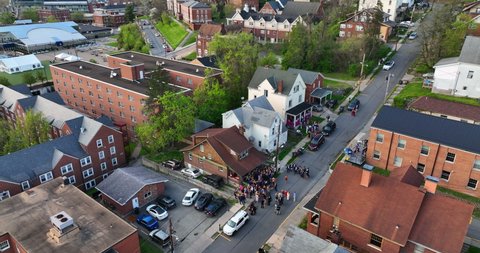 Fraternity sorority Greek life at college party. Students partying, drinking at frat house. Exterior aerial of students dressed up. Aerial view.