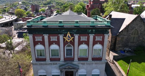 Cumberland , MD , United States - 04 29 2022: Mason society. Freemason masonic building for meetings. American USA Maryland state flags. Rising aerial reveal in Cumberland MD.