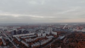 Autumn in the city, drone video. Red trees in cloudy weather. urban landscape