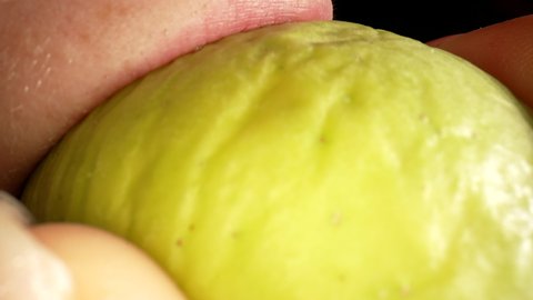 Macro shot of eating an apple. Bite off an apple. Slow motion. Macro food concept