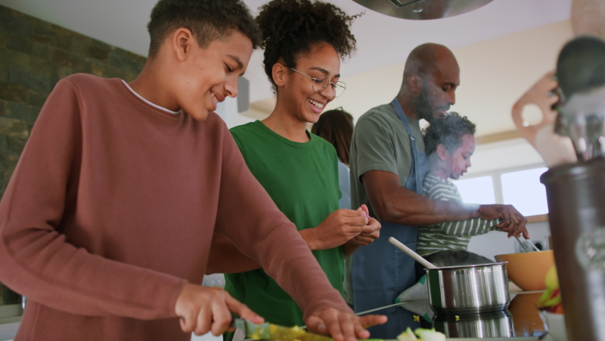 Happy multiracial family with three children cooking together at home. Royalty-Free Stock Footage #1090175973