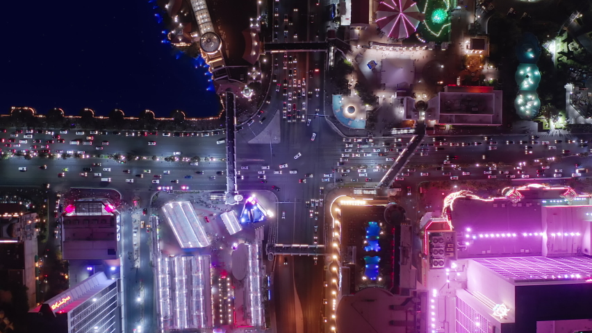 Beautiful top view time-lapse of car traffic at hotel buildings. 4K drone aerial above night city. Urban cityscape concept, casino business ads in night lights, energy power. Las Vegas, USA Apr 2022