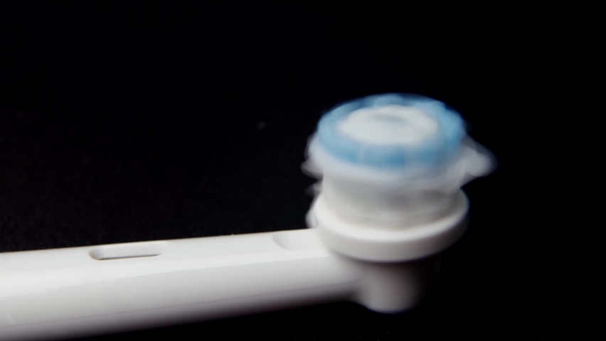 Macro-video of the electric brush working and the application of toothpaste. A close-up shows the nozzle head, the villi of which move rapidly. Oral hygiene concept, a Healthcare Video by wedmoments.stock