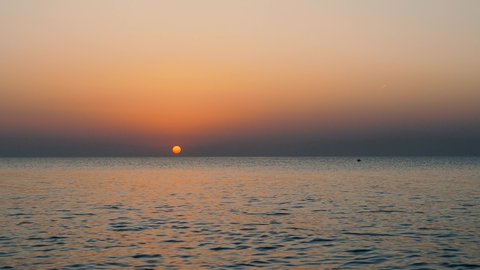 Beautiful sea sun set with seagulls. A flock of birds flies over the sunset sea. 