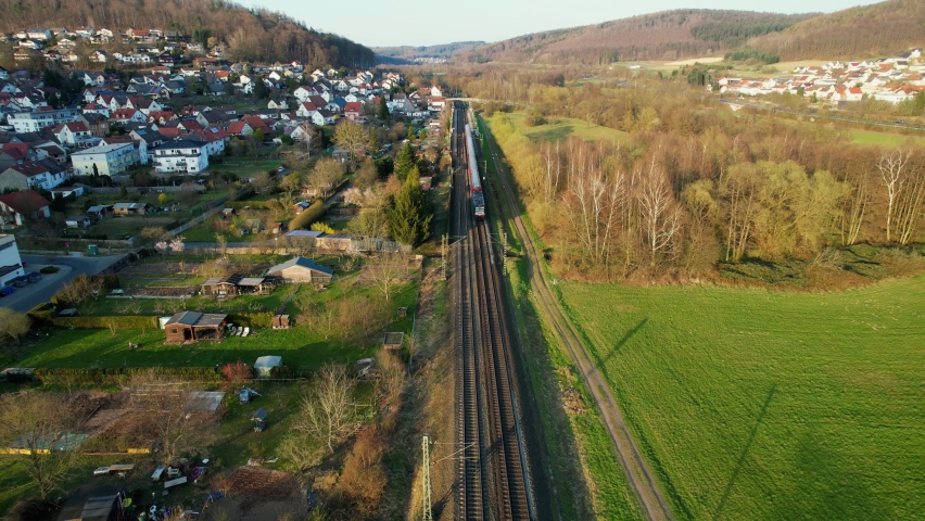 Aerial view of a train on the Deutsche bahn, spring, evening in Germany - reverse, pull back, drone shot Royalty-Free Stock Footage #1090181157
