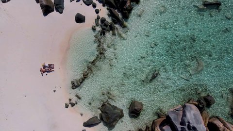 Anse Cocos beach, La Digue Island, Seyshelles, Drone aerial view of La Digue Seychelles bird eye view.of tropical Island, couple men and woman walking at the beach during sunset at a luxury vacation