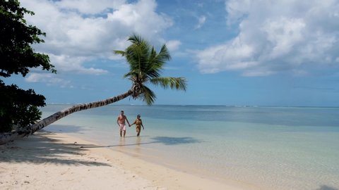 Anse Takamaka beach Mahe Seychelles, a tropical beach with palm trees and a blue ocean. Seychelles, couple man and woman on the beach, 