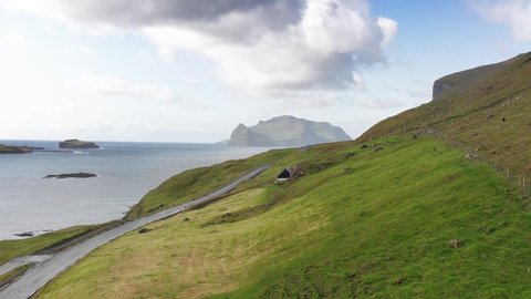 Faroe Island road along beautiful coast. Faroe Vagar island, Denmark. Forward aerial flight