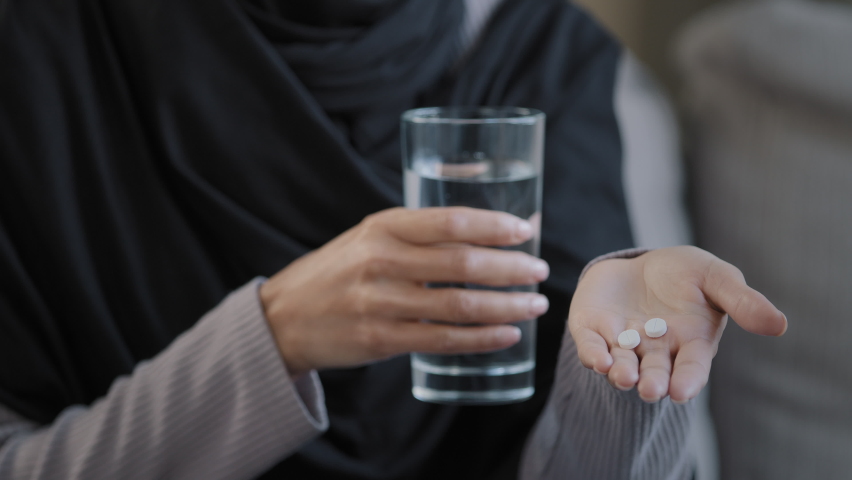 Unwell young woman drinking medical pill vitamin antibiotic with water ...