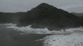 Waves crashing stones in overcast weather