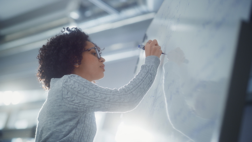 Black Female Scientist Solving Problems and Math Equation while Using Whiteboard. Genius, Conceptuality and Breakthrough in Science Concept Royalty-Free Stock Footage #1090193307