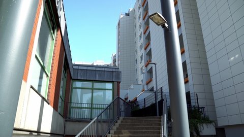Bremen Tenever social housing blocks under blue sky. Tilt up 4k shot of stairs under the apartment building.