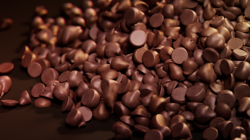 Dark chocolate chips spill out on the brown background. The backdrop for confectionery, candy shop. The pile of tiny cocoa candies. Delicious toppings for cookies or biscuits. Sweet temptation. | Shutterstock HD Video #1090195335