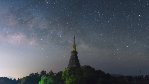 Time Lapse 4K of The Milky Way Galaxy moving over a sacred temple at Doi Inthanon National Park, Chiang Mai, Thailand. Night lapse from night to day. Starry night.