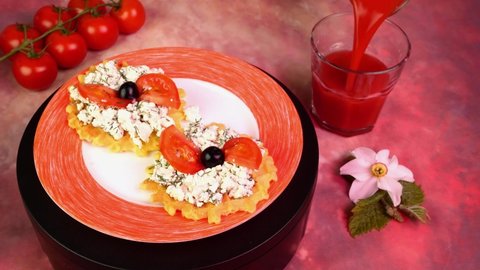 Vegetarian sandwich with cottage cheese, dill, tomatoes and olives, rotate slowly. Pouring tomato juice in drinking glass. Pink light.