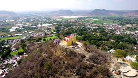 Orbital drone shot of church on top of hill in Atlixco Mexico