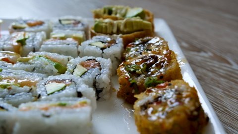 Close-up trucking slider shot of delicious looking mixed sushi platter