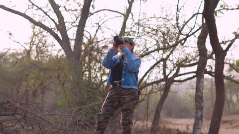 Sasan Gir, Gujarat, India- Circa 2022: Woman professional photographer with dslr camera outdoors portrait. Indian girl in  Gir forest taking pictures. Hobby, lifestyle, travel, people concept