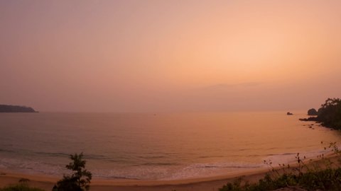 Wide angle time lapse of beach as seen from cliff above the Cabo De Rama beach at Goa in India. Time lapse of sunset at the beach. Nature Beach background. Summer holidays. Ocean wave background. 
