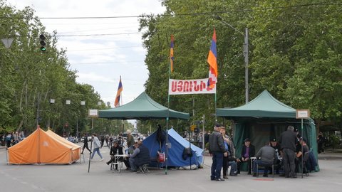 Yerevan, Armenia - May 9, 2022: Opposition tent camp at the crossroads with blocked traffic. Anti-government protesters in tents sign citizens' consent to the resignation of the prime minister