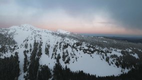 Aerial view of snowy mountain slope in Oregon, USA, drone video of winter landscape with evergreen trees near Crater Lake
