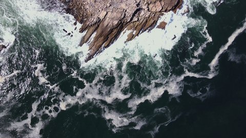 Top-down aerial of rocky outcrop in atlantic, with Doringbaai lighthouse
