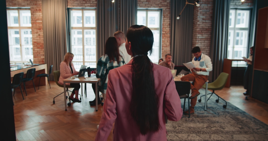 Rear view young beautiful female boss, executive manager enters office welcoming happy colleagues slow motion. | Shutterstock HD Video #1090213077