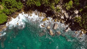 Aerial view shot. Drone camera over white beach sand and sea water clear. Nature video view of beautiful tropical beach and sea in sunny day. Palm tree at beach. At Phuket, Thailand.