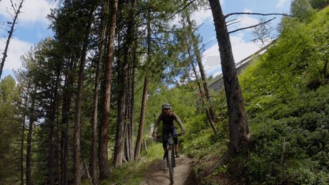 Mountain biker riding down a pathway in the forest. Rider point of view, mountain biking on high mountain terrain 