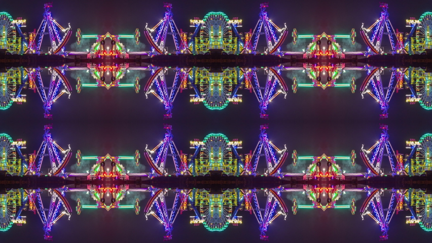 A timelapse of the lit up rides at a funfair in barcelona made into abstract mirrored pattern 