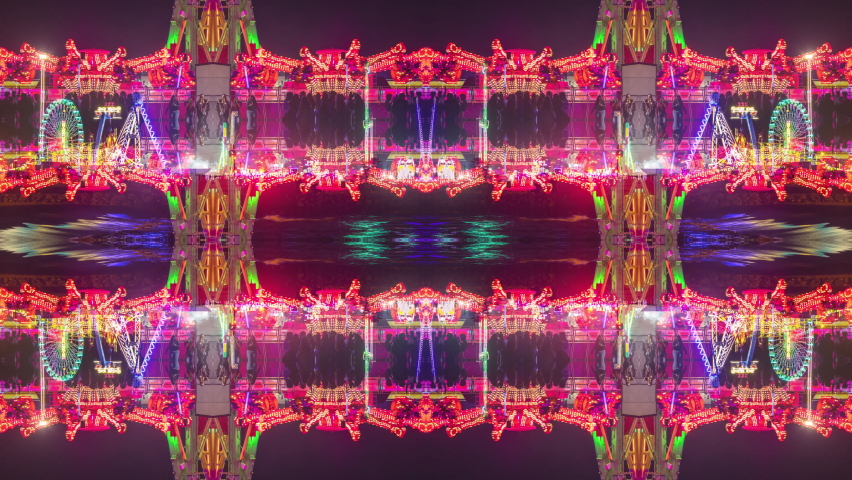 A timelapse of the lit up rides at a funfair in barcelona made into abstract mirrored pattern 