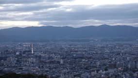 KYOTO, JAPAN - DEC 2021 : Aerial high angle sunset view of Kyoto city. Scenery of mountain, streets and buildings around downtown central area. Japanese nature and traditional old town concept video.