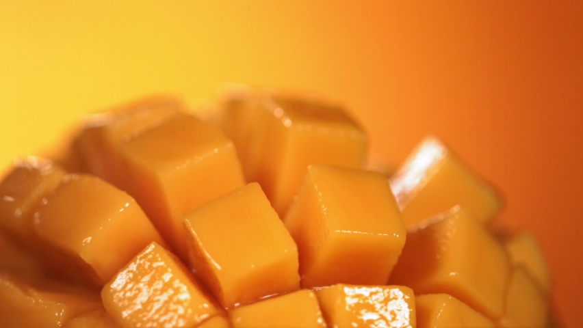Slow Motion Shot of Mango Juice Splashing through Mango Cube Slices Royalty-Free Stock Footage #1090222563