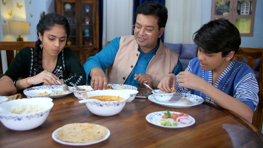 A Bengali family - Father and kids having food at the dining table - quality time, family bonding. A happy Bengali family enjoying meal together- Single father, nuclear family, teenage kids Royalty-Free Stock Footage #1090224755
