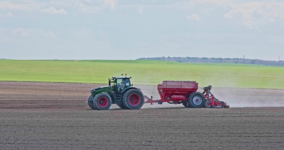 tractor cultivator or seeder plows the land, prepares for crops. dust on field Royalty-Free Stock Footage #1090225453
