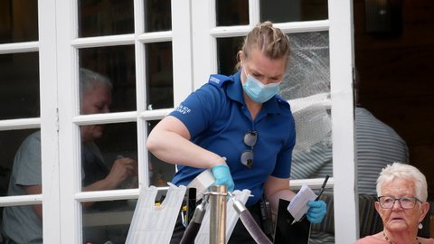 Norwich, Norfolk, United Kingdom. May 6, 2020. Norfolk Police Forensic Services female officer working at a crime scene wearing mask.