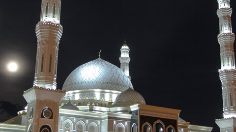 Illuminated The Hazrat Sultan Mosque in Astana timelapse hyperlapse at night with full moon, Nur-Sultan city, Kazakhstan