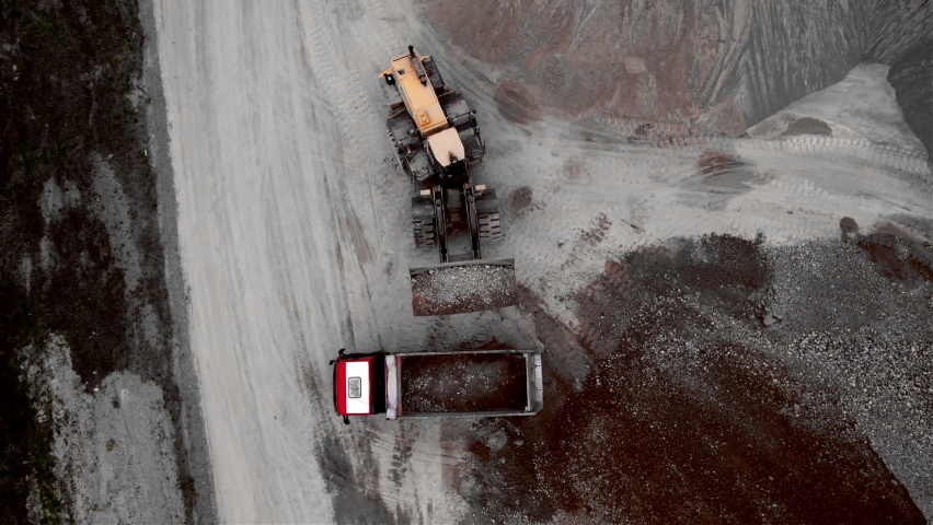 Wheel loader load gravel and crushed stones in dump truck. Front end loader loading of crushed stone. Earthworks in quarry. Heavy machinery on open-pit mining. Tipper truck gravel transport.   Royalty-Free Stock Footage #1090228075