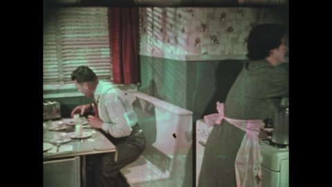 1950s: man with suspenders and tie uses juicer to squeeze orange, talks with woman with coffeepot on stove, man sits at table, woman pours coffee, man drinks orange juice