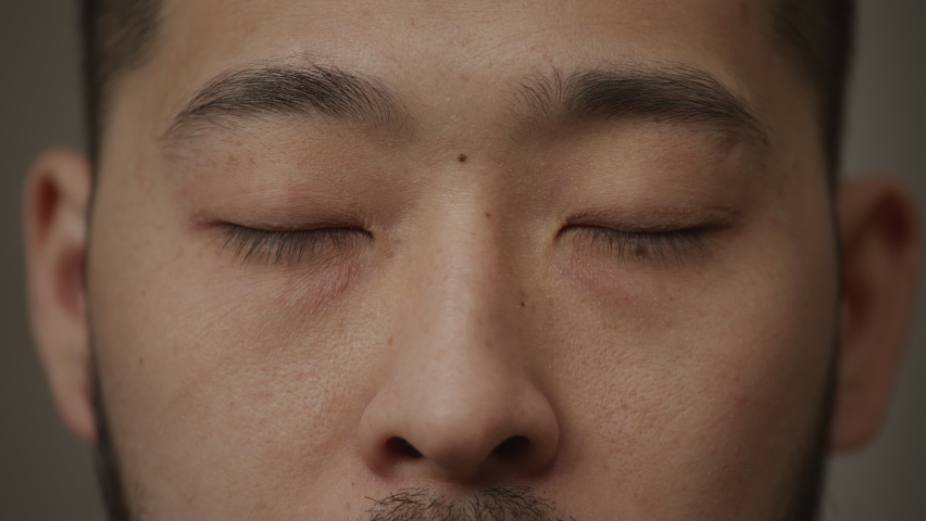 Extreme close up of an asian man's eyes opening and looking at camera | Shutterstock HD Video #1090231441