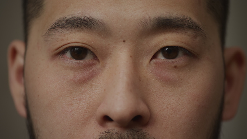 Extreme close up of an asian man's eyes opening and looking at camera Royalty-Free Stock Footage #1090231441